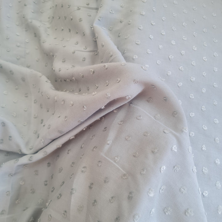 Viscose dobby textured spot polkadot dress fabric. Sage green and white