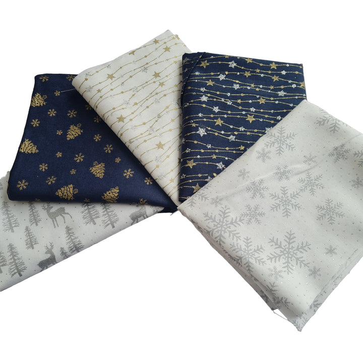 Five fabric fat quarters in navy and white with Christmas winter-themed patterns