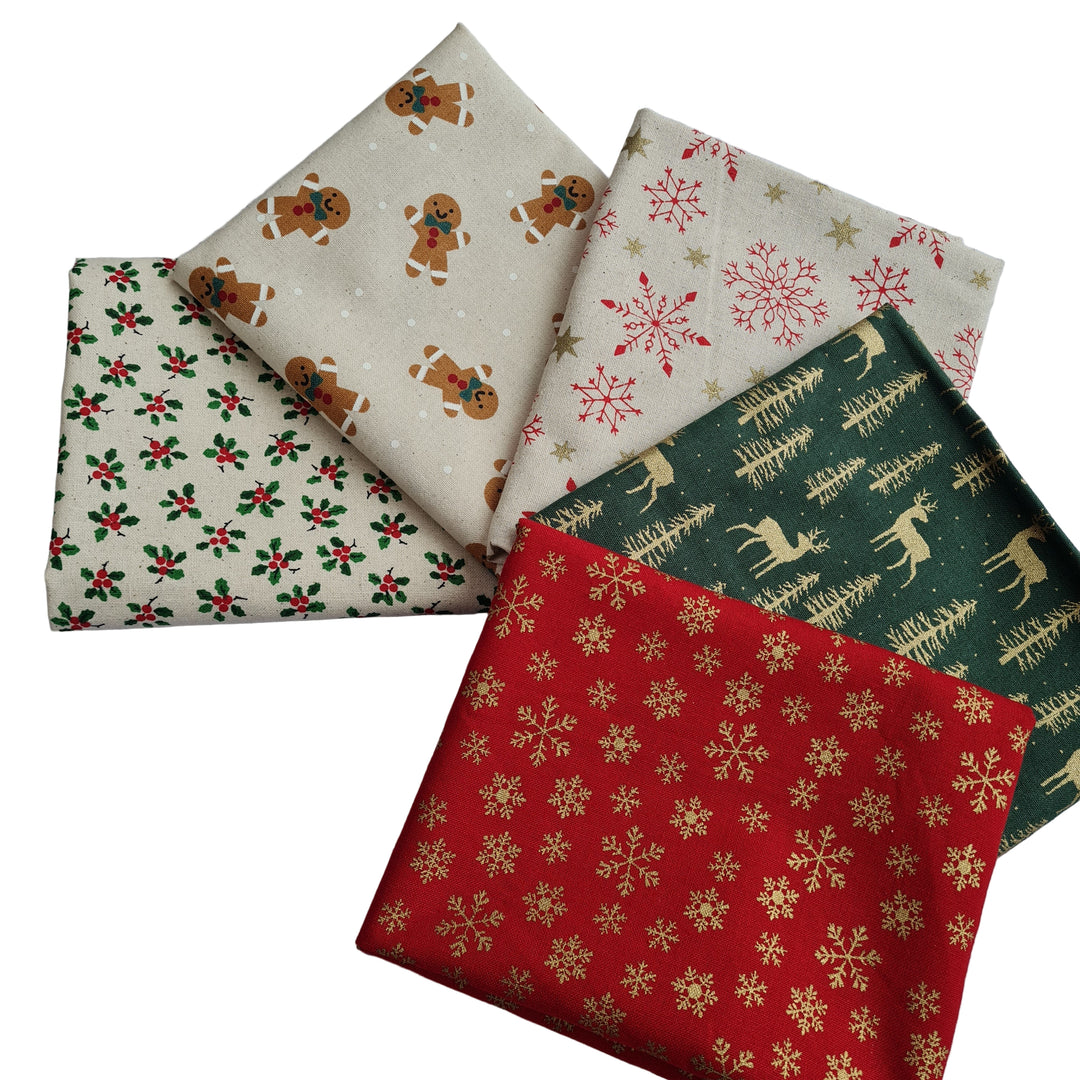 Five festive fabric fat quarters with Christmas patterns featuring gingerbread man